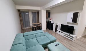 奥托佩尼Apartament CWA 1 Aeroport Otopeni的客厅配有蓝色的沙发和平面电视。