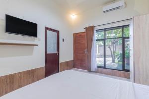 马塔兰Penginapan Asri的卧室配有一张床,墙上配有电视。