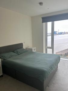 WoolwichLuxury Riverside Apt with easy access to Central London, O2, Excel centre and Parking的一间卧室设有一张床和一个大窗户