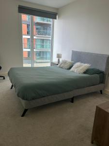 WoolwichLuxury Riverside Apt with easy access to Central London, O2, Excel centre and Parking的一张位于带大窗户的房间内的床铺