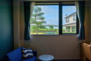 Tōna奥松島LANEホテル的客厅设有蓝色的沙发和大窗户