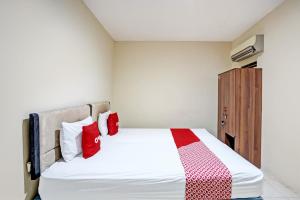 LontarOYO Life 93111 Garden Homestay 2 Merlion的一间卧室配有红色和白色枕头的床