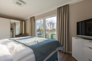 瓦尔内明德Haus Leuchtfeuer/Eagle的酒店客房设有一张床和一个大窗户