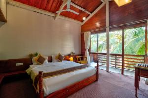 卡兰古特Aqua Marina Beach Cottages的一间卧室设有一张床和一个大窗户
