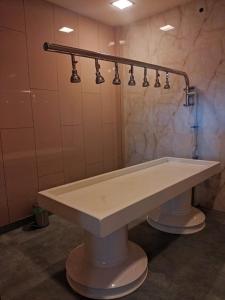 班加罗尔Nirvana Club Resort and Spa的浴室里设有一个大型的白色水槽,配有灯光