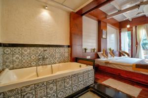 卡兰古特Aqua Marina Beach Cottages的一间带浴缸的浴室和一张位于客房内的床
