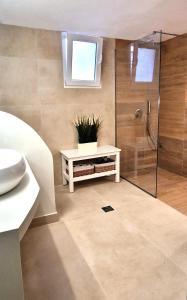 斯派赛斯Summer house in Spetses的带淋浴的浴室和带植物的长凳
