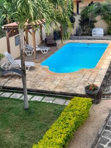 潘托皮芒Villa santa avec piscine et jardin的一座房子旁的游泳池,里面种着棕榈树