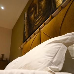波佐利Mini Hotel - Angolo Di Paradiso -的一张带白色枕头的床铺的壁橱