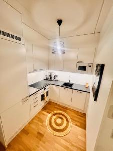 塞伊奈约基2 Room / Central Railway / Free parking的厨房铺有木地板,配有白色橱柜。