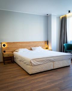 卡尔洛沃Family Hotel Pak Tam的一间卧室配有一张大床和木制床头板
