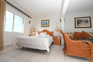 奥拉涅斯塔德E Solo Aruba Apartments的一间卧室配有一张床和一把椅子