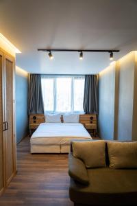卡尔洛沃Family Hotel Pak Tam的一间卧室配有一张大床和一张沙发