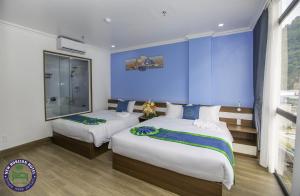 吉婆岛CHÂN TRỜI MỚI -NEW HORIZON HOTEL的一间卧室设有两张床和蓝色的墙壁