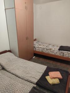 兹拉蒂博尔Apartman Gogi的一间卧室配有两张床、一个橱柜和毛巾