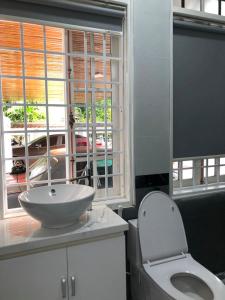 顺化Nhat Long Homestay的一间带水槽和卫生间的浴室以及窗户。