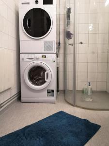诺尔雪平Stor lägenhet för familj eller företag的带淋浴的浴室内的洗衣机和烘干机