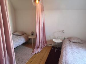 诺尔雪平Stor lägenhet för familj eller företag的一间卧室配有两张床和粉红色窗帘