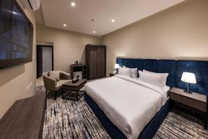 利雅德Towlan Qurtuba 2的酒店客房带一张大床和一把椅子