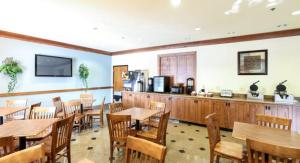 亨德森维尔亨德森维尔机场山林假日套房酒店的一间带木桌椅的餐厅和一间厨房
