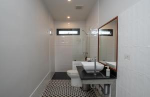莱卡邦Ploen Pirom的一间带卫生间、水槽和镜子的浴室