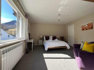 格伦科Strathassynt Guest House的一间卧室设有一张床和一个大窗户