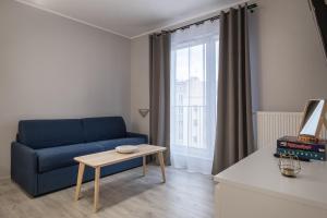 格丁尼亚02 Gdynia Premium - Apartament Mieszkanie dla 4os的客厅配有蓝色的沙发和桌子