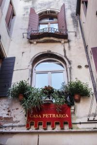 威尼斯卡萨皮特罗卡酒店的一座建筑,上面有盆栽的窗户
