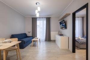 格丁尼亚02 Gdynia Premium - Apartament Mieszkanie dla 4os的客厅配有蓝色的沙发和桌子