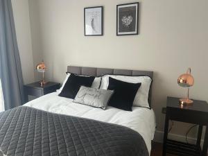 里克曼斯沃斯New build 1 bedroom modern apartment Rickmansworth的一张带黑白枕头的床和两盏灯