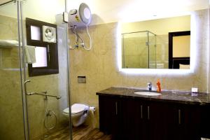 古尔冈When In Gurgaon - ARTEMIS HOSPITAL 1 Min Walk, FORTIS & MEDANTA 4 Mins Drive的浴室配有盥洗盆和带镜子的淋浴