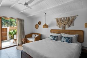 莫尔吉姆Azora by Ayatana, Goa的卧室配有床、椅子和窗户。