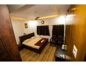 贾巴尔普尔Bisman Lodge, Jabalpur的一间卧室配有一张床和一把椅子