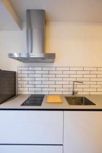 塞维利亚AT Presidente Nº1 apartamento privado completo的白色的厨房设有水槽和炉灶。
