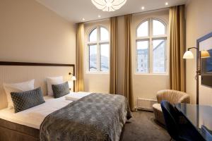 哥本哈根阿斯科特酒店的酒店客房设有一张床、一张书桌和窗户。