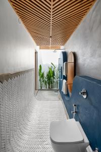 莫尔吉姆Azora by Ayatana, Goa的一间带卫生间和蓝色墙壁的浴室