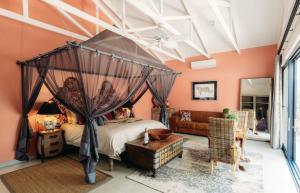侯斯普瑞特Safari Moon Luxury Bush Lodge的一间卧室配有天蓬床和沙发