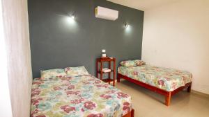 巴卡拉尔Las Palmas的一间卧室设有两张床和床头柜