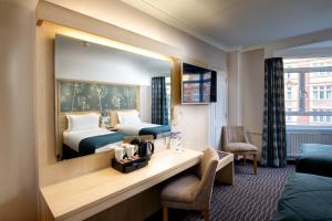 伦敦Bedford Hotel的酒店客房,设有两张床和镜子