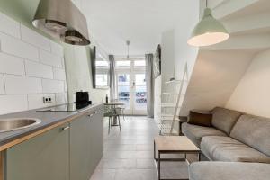 乌得勒支Beautiful apartment in vibrant Utrecht City Center的厨房以及带沙发的起居室。