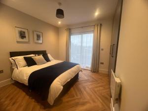 里克曼斯沃斯New 2 Bedroom Apartment Rickmansworth Town Centre的一间卧室设有一张大床和一个窗户。