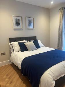 里克曼斯沃斯New 2 Bedroom Apartment Rickmansworth Town Centre的一间卧室配有一张带蓝白色枕头的大床