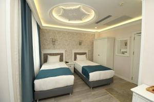 伊斯坦布尔Novus Hotel İstanbul的一间卧室设有两张床和天花板