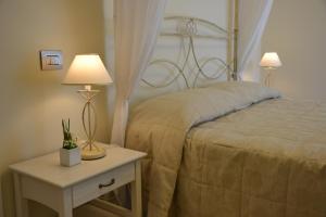 托尔托雷托因坎提度假酒店的一间卧室配有一张床和一张带两盏灯的桌子。