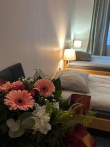 吕尔Appart O'key的一间酒店客房,床边有一束鲜花