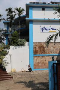 乞拉朋齐Royal View Resort , Cherrapunji的停在建筑物前的摩托车,有标志