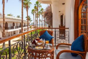 沙姆沙伊赫Seti Sharm Palm Beach Resort Families and couples only的棕榈树阳台的桌椅