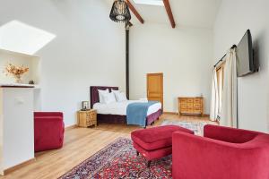 Saint-Sulpice-et-CameyracDomaine de Badine, Bordeaux centre 15mn的一间卧室配有一张床和两张红色椅子