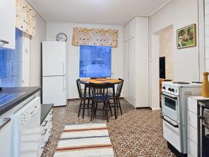 YlitornioMäki-mummola的一间厨房,配有白色家电和桌椅