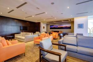 圣地亚哥拉昆塔圣地亚哥机场LQ酒店的带沙发、椅子和电视的等候室